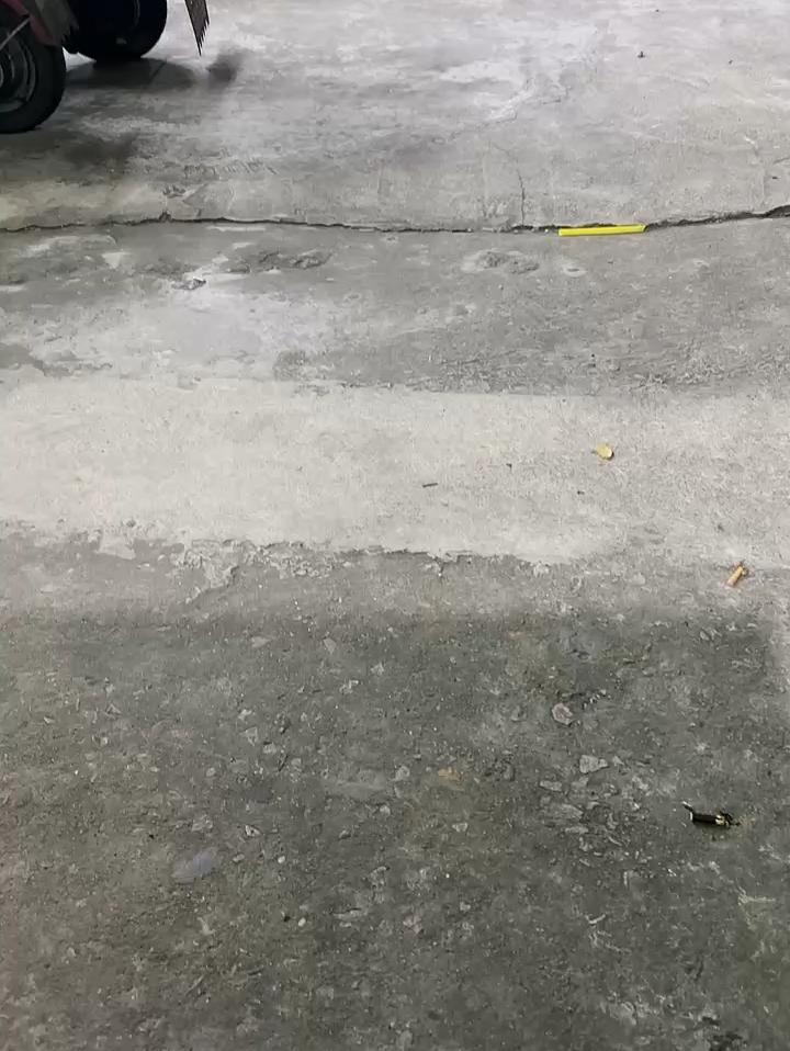 停车场内，几辆摩托车整齐停放，地面略显陈旧