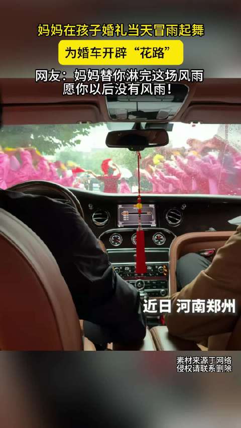 #河南妈妈婚礼当天冒雨为婚车开路# 近日，河南。妈妈在孩子婚礼当天冒雨起舞，为婚车开辟“花路