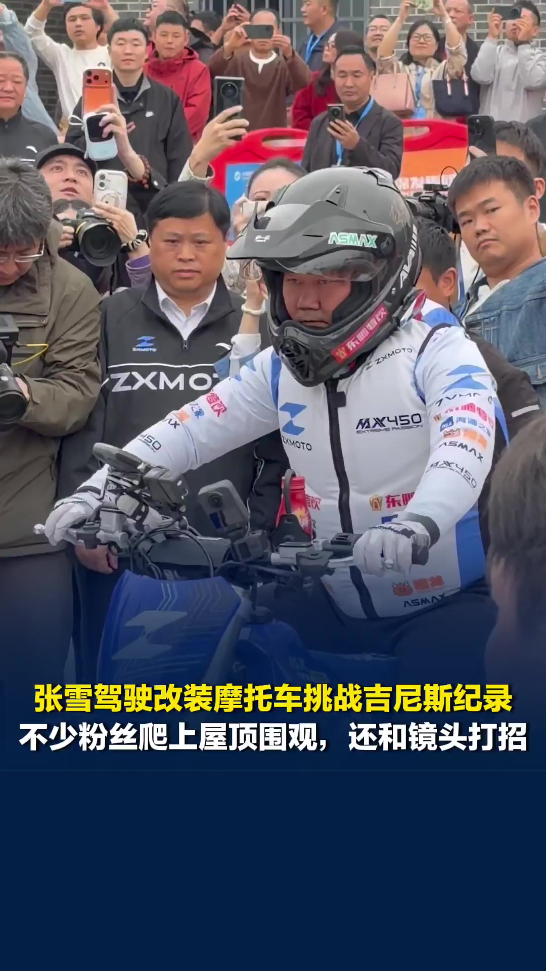 张雪驾驶改装摩托车挑战吉尼斯纪录，不少粉丝爬上屋顶围观，还和镜头打招