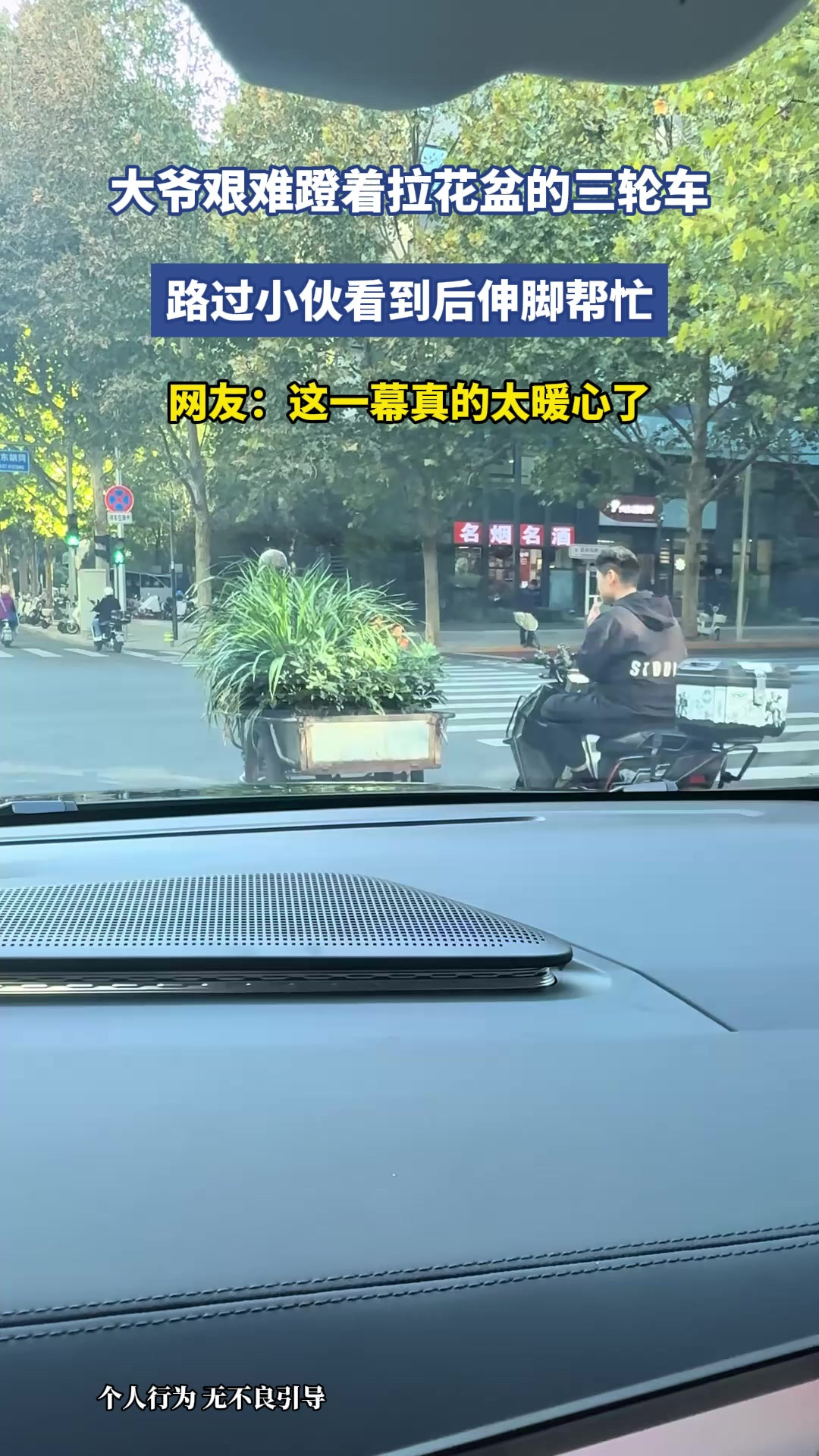 大爷艰难蹬着拉花盆的三轮车，路过小伙看到后伸出脚助力，网友：这一幕真的太暖心了