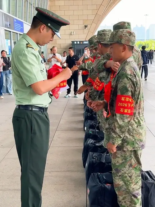 部队接兵领导给新兵战士发放袖章，准备出发 奔赴军营