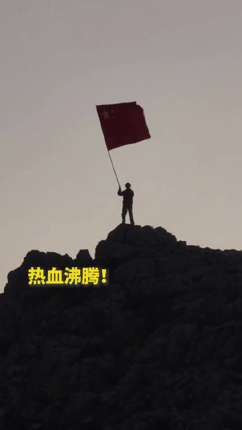 【热血沸腾！#当中国红在山巅迎风飘扬#】#贺兰山朝霞配国旗太燃了#10月1日，宁夏贺兰山。男子迎朝霞