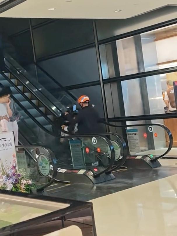 外卖员推电动车上扶梯摔倒，这操作真的看不懂。