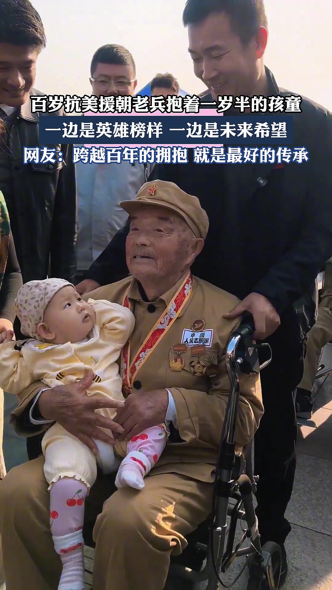 百岁抗美援朝老兵抱着一岁半的孩童，一边是英雄榜样，一边是未来希望。