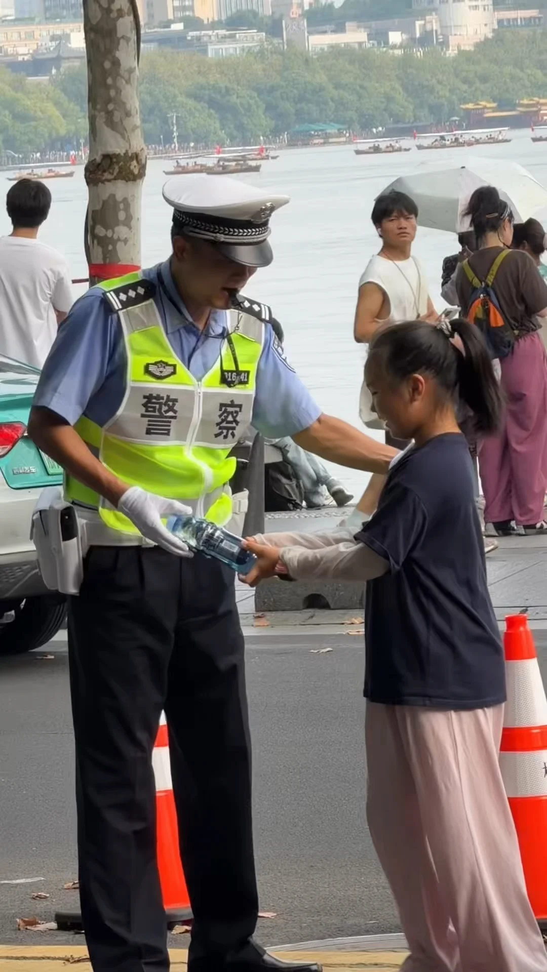 交警叔叔汗水湿透衣背，路人小女孩递过去一
