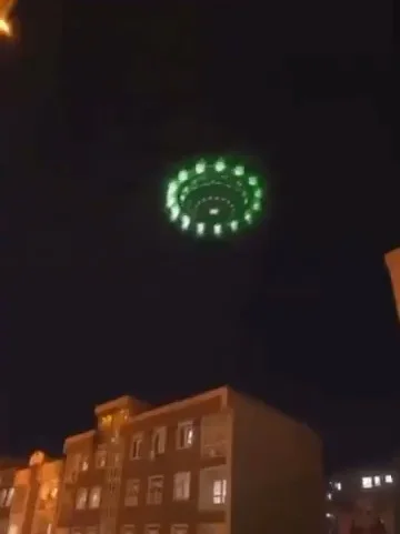 2024年5月26日，伊朗德黑兰上空出现绿色圆盘状UFO。物体低空悬停，底部带有同心圆绿色光环，中心