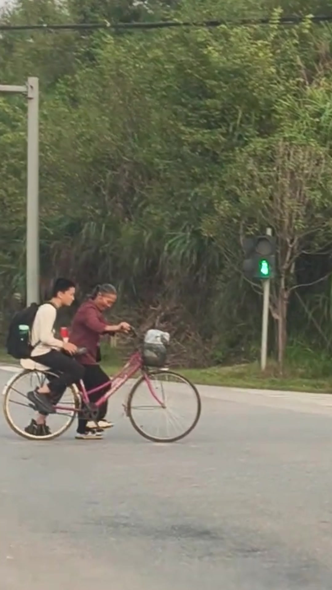 碰见一个娭毑推着自行车，接初中生过马路中，网友：不能怨孩子，是家长不放手